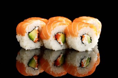 fresh delicious Philadelphia sushi with avocado, creamy cheese, salmon and masago caviar isolated on black with reflection clipart