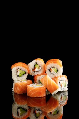 delicious Philadelphia sushi with avocado, creamy cheese, salmon and masago caviar isolated on black clipart