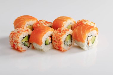 Beyaz arka planda somon ve masago havyarlı lezzetli Philadelphia ve California suşisi.