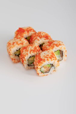 delicious California roll with avocado, salmon and masago caviar on white surface clipart