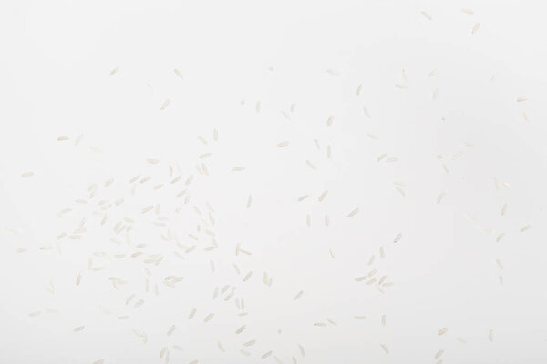 top view of raw rice scattered on white surface