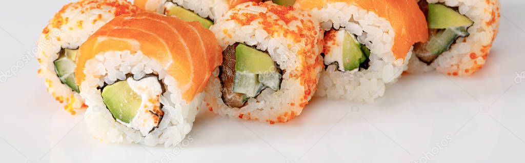 delicious Philadelphia and California sushi with salmon and masago caviar on white background, panoramic shot