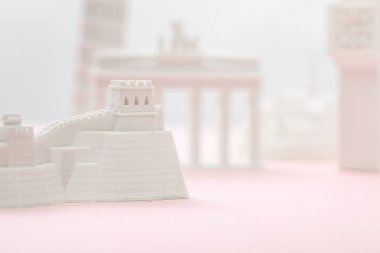 selective focus of small great wall figurine near statuettes on grey and pink  clipart