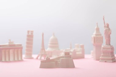 selective focus of great wall figurine near statuettes on grey and pink  clipart