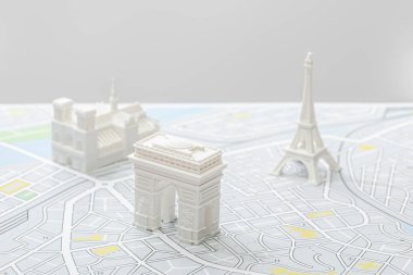 selective focus of small figurines on map of paris isolated on grey   clipart
