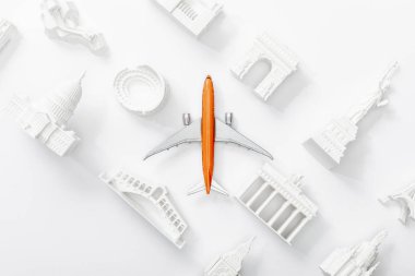 Avrupa 'nın farklı ülkelerinden küçük heykelciklerin yanındaki oyuncak uçak manzarası beyaza izole edilmiş. 
