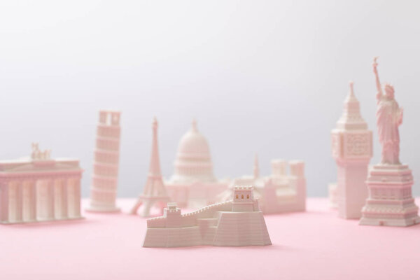 selective focus of great wall figurine near statuettes on grey and pink 