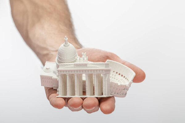 cropped view of man holding souvenirs from different countries isolated on white 