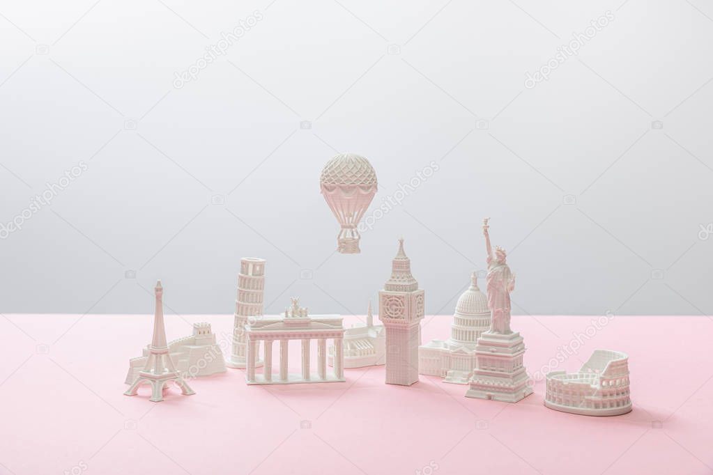 small figurines from different countries on grey and pink 