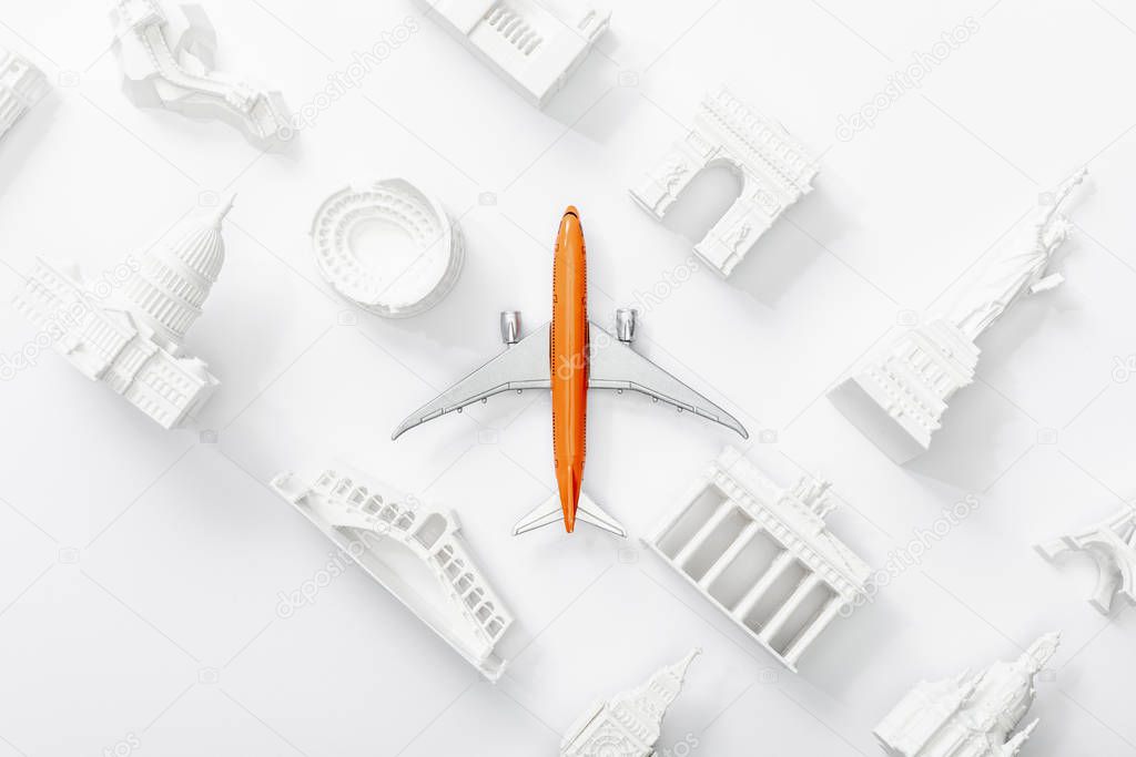 top view of toy plane near small statuettes from different countries in europe isolated on white 