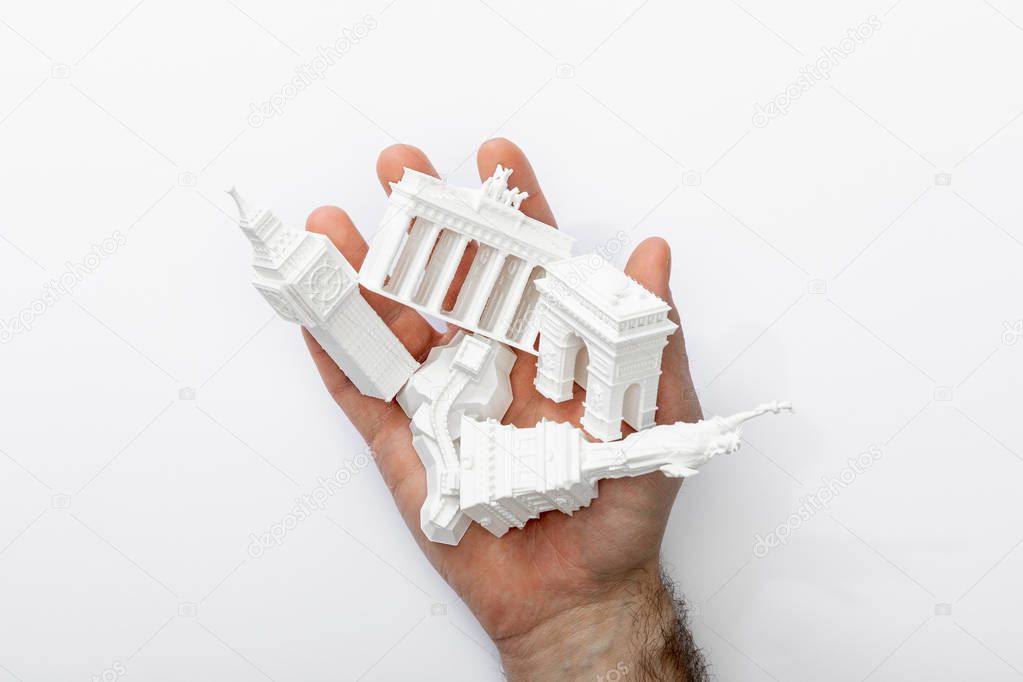 top view of man holding small figurines from europe isolated on white 