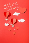 horní pohled na papírové srdce ve tvaru vzduchové balónky v mracích v blízkosti se všemi mými nápisy na červeném pozadí