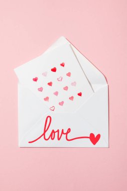 top view of greeting card with hearts in white envelope with love lettering on pink clipart
