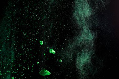 Siyah arka planda yeşil renkli holi boya patlaması