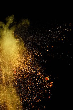 yellow colorful holi paint explosion on black background clipart