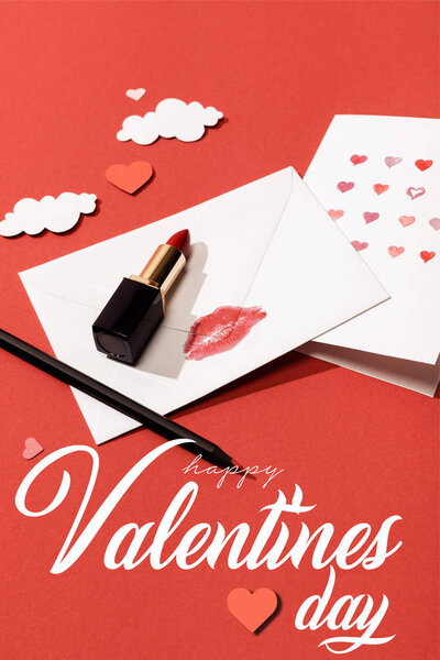 paper clouds and hearts, lipstick, greeting card and envelope with lip print near happy valentines day lettering on red background