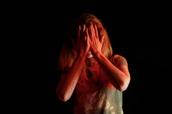 Kadın Yüzünü Turuncu Renkli Holi Boyasıyla Kaplamış Siyah Arka Planda — Stok fotoğraf