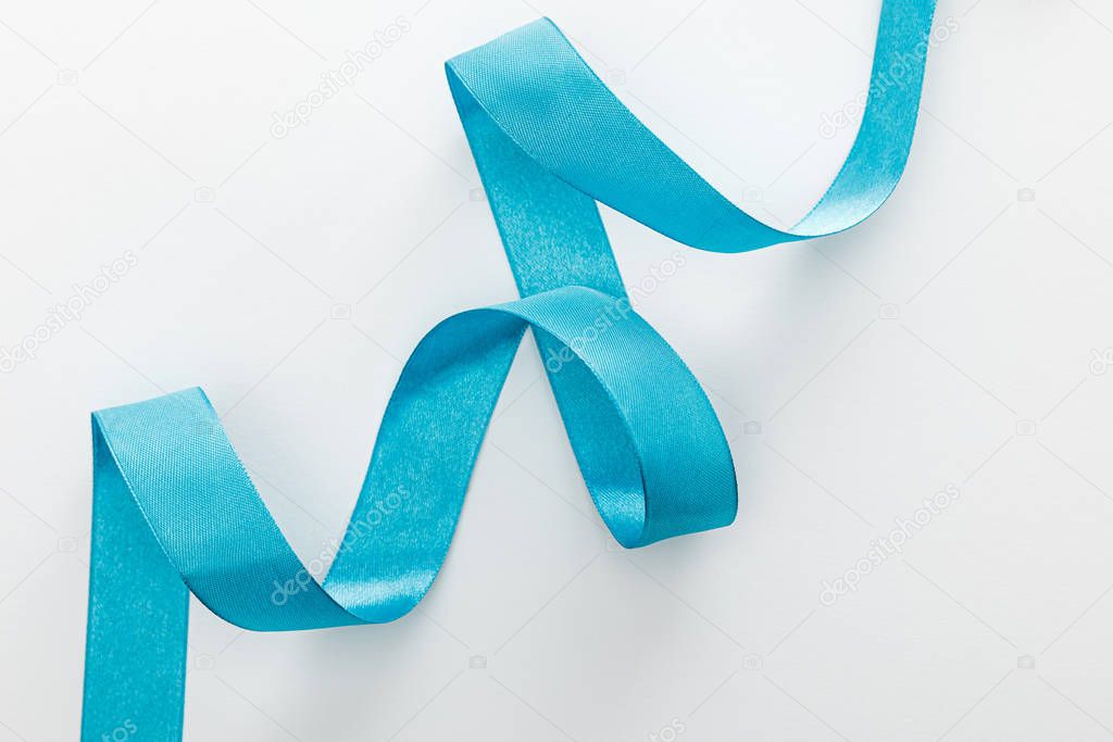 top view of blue decorative curved ribbon on white