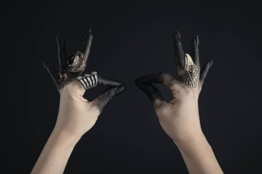 Siyah boyalı cadı elleri ve siyah mücevherli yüzükler. 