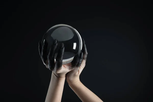 黑漆漆的女巫手拿着用黑色隔离的水晶球的剪影 — 图库照片