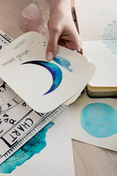 木桌上摆放着印有月相水彩画的占星家卡片的剪影 — 图库照片
