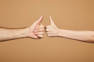 Kadın ve erkeğin bej renkte baş parmak gösterdikleri kesikli görüntü