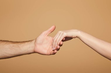 Bir erkeğin bej üzerinde izole edilmiş bir kadının elini tutuşu görüntüsü