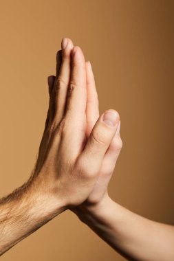 Kadın ve erkeğin bej rengi için beşlik çakışının kırpılmış görüntüsü