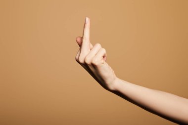 Bej üzerinde izole edilmiş orta parmak gösteren kadın görüntüsü