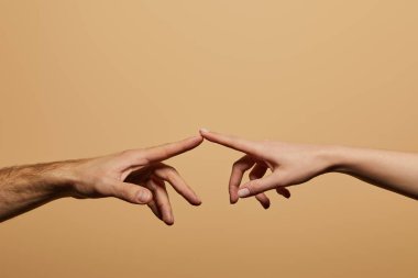 cropped view of man and woman touching with fingers isolated on beige clipart