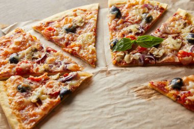 Lezzetli İtalyan pizzası, zeytinli, ahşap masadaki kağıt fırınında.