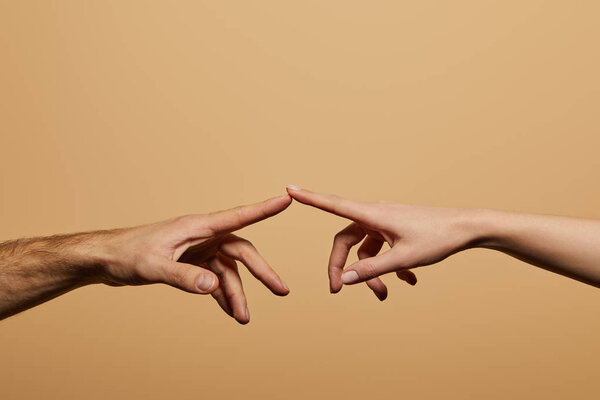 cropped view of man and woman touching with fingers isolated on beige