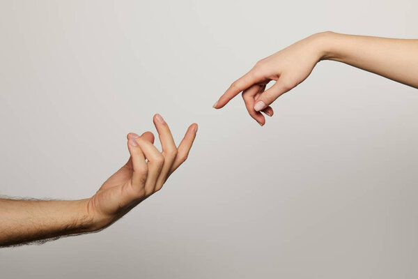 cropped view of man and woman reaching for each other isolated on white