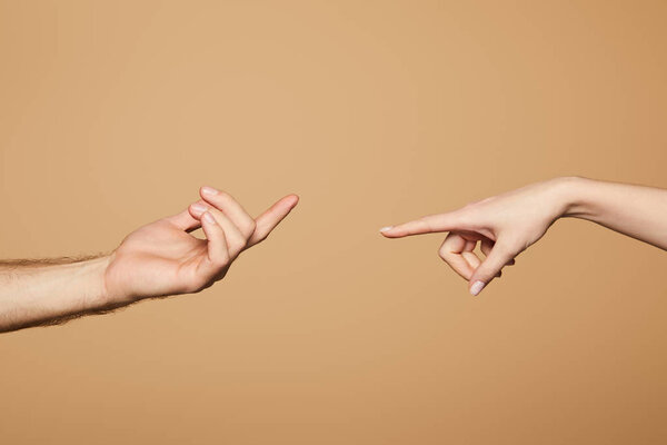 cropped view of man and woman reaching each other with fingers isolated on beige