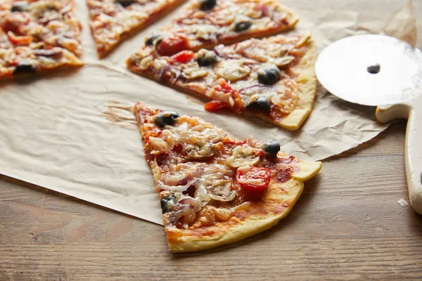 Zbliżenie Widok Cięcia Pyszne Włoskie Pizzy Oliwkami Papierze Pieczenia Pobliżu — Zdjęcie stockowe