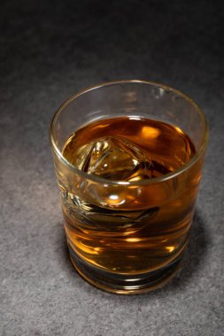 Alkollü bardakta buz küpleri Gri yüzeyde içki 