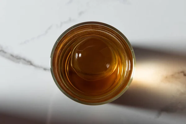 Widok Góry Kostki Lodu Szklance Whisky Białej Powierzchni Marmuru — Zdjęcie stockowe