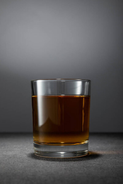 cold alcohol drink in glass on grey background 