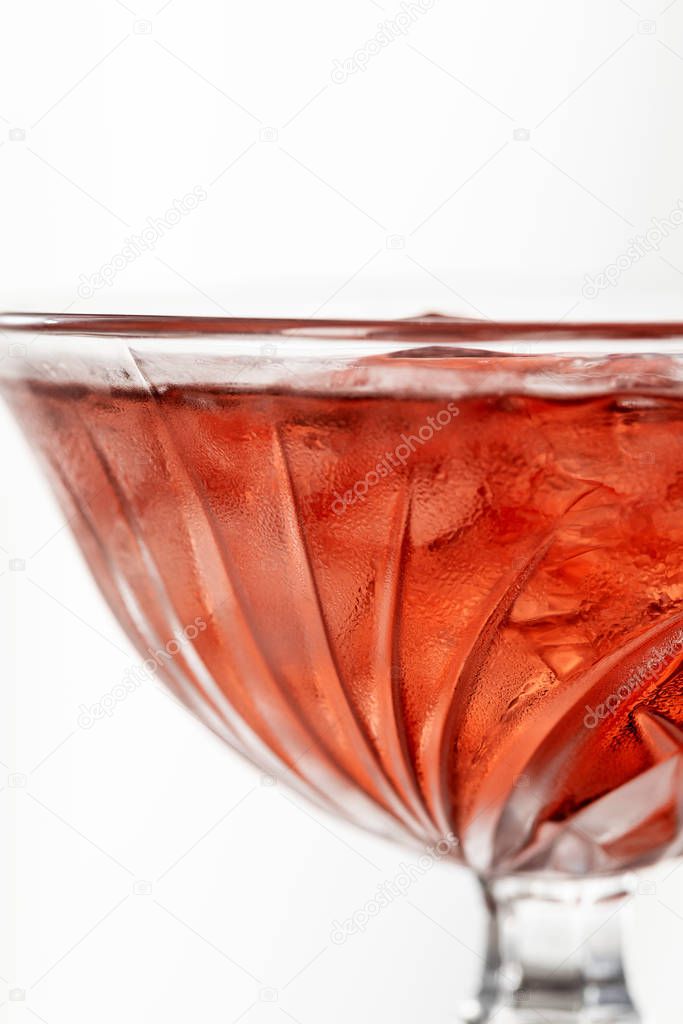 close up of red cocktail with ice cubes isolated on white 