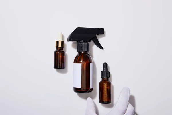 Cropped View Hand Glove Dispenser Cosmetic Bottles Oil Grey Background — Stock Photo, Image