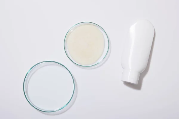 灰色の背景にチューブ付き研究室用ガラス製品の化粧品クリームのサンプルのトップビュー — ストック写真