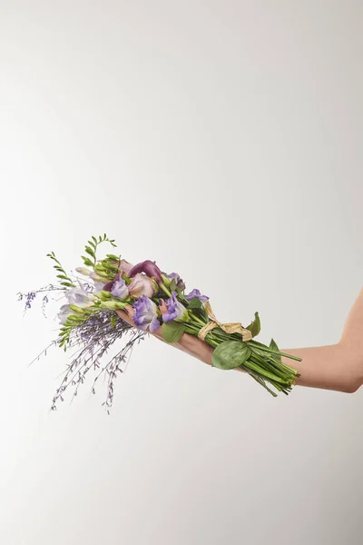 白に紫と紫の花の花束を持っている女性のクロップドビュー — ストック写真