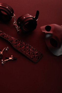 sex toys in dark lighting on red background clipart