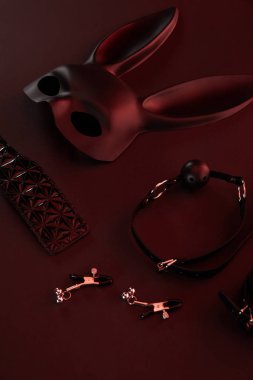 sex toys in dark lighting on red background clipart