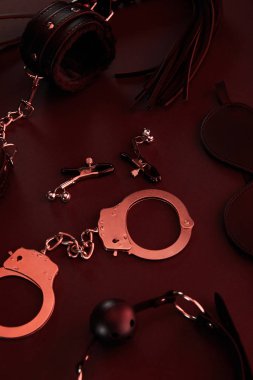 Kırmızı arka planda siyah ışıklı seks oyuncaklarının görüntüsünü kapat