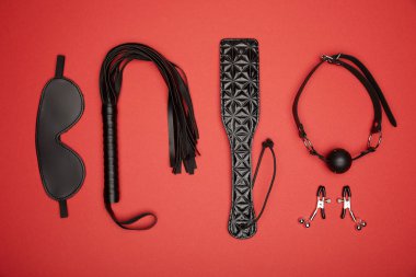 flat lay with various black sex toys isolated on red clipart