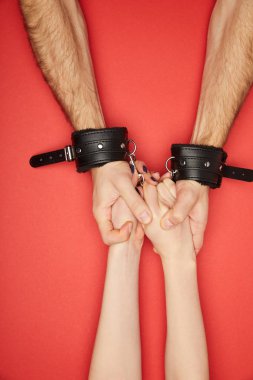 Kırmızıda izole edilmiş bir kadınla elleri kelepçeli bir adamın görüntüsü.