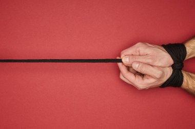 Kırmızıda izole edilmiş ellerinde ip olan adam manzarası
