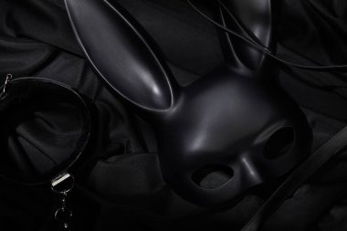 Siyah tekstil arka planında yaka ve tavşan maskesi üst görünümü