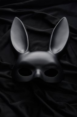Siyah tekstil arka planında tavşan maskesinin üst görünümü